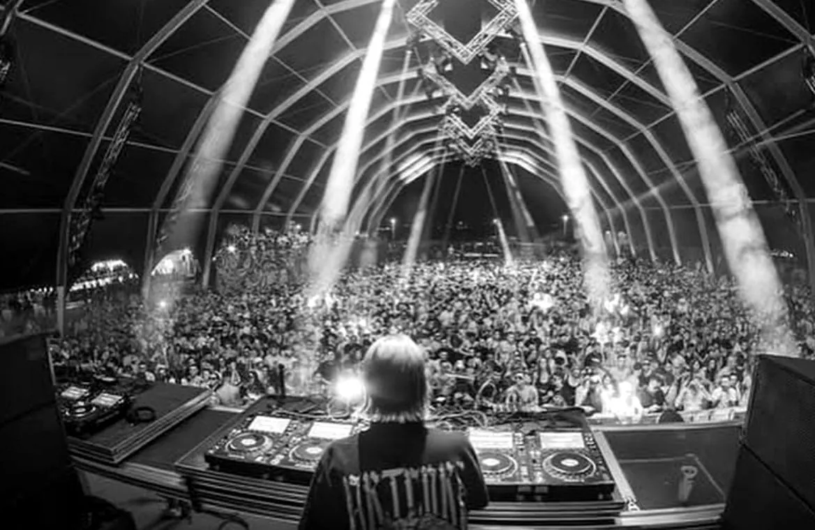 Escenario de festival con el público visto desde la cabina del DJ